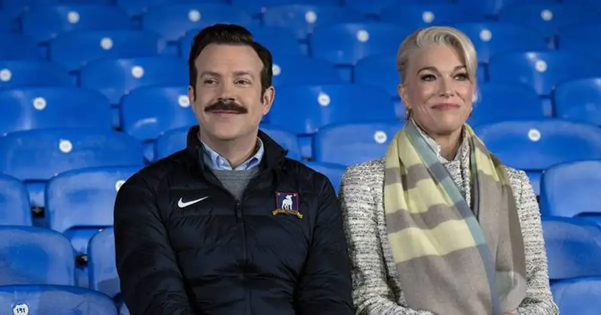 Imagem de Jason Sudeikis, como Ted Lasso, e Hannah Waddingham, como Rebecca Welton, em uma cena de conversa intensa na série "Ted Lasso".